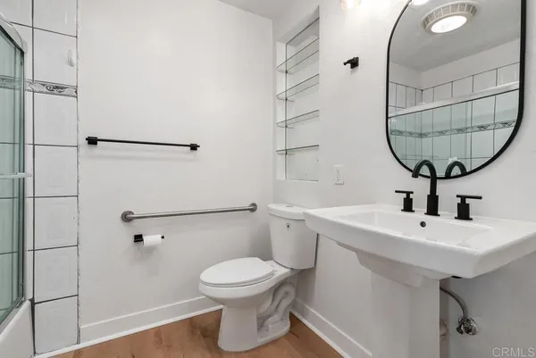 a bathroom with a toilet a sink and a mirror