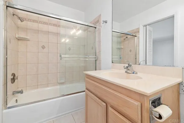 a bathroom with a shower sink vanity and mirror