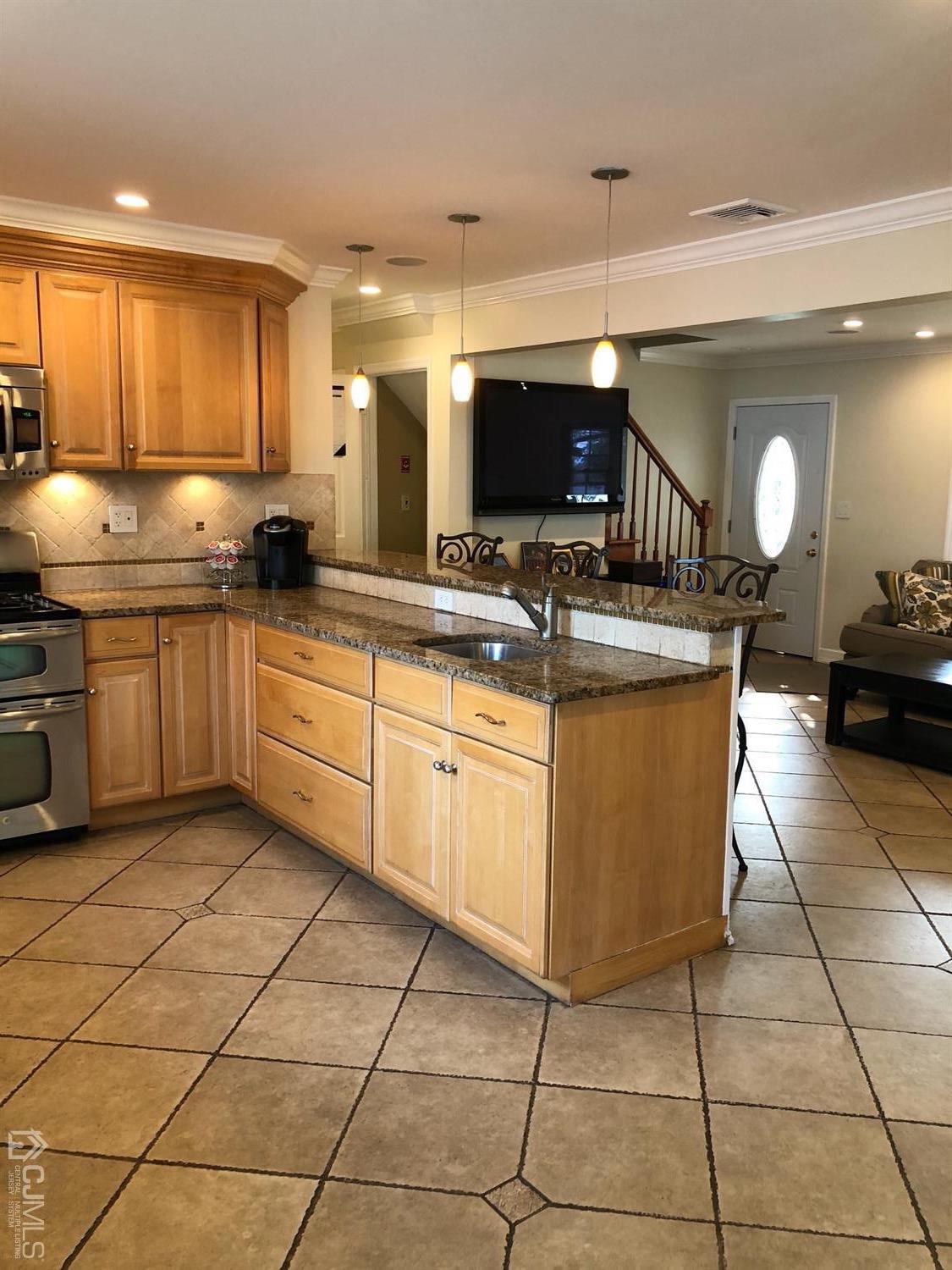 44 Hillcrest Road Colonia, NJ 07067 - Photo 4 of 23 a kitchen with a sink a counter top space cabinets and stainless steel appliances