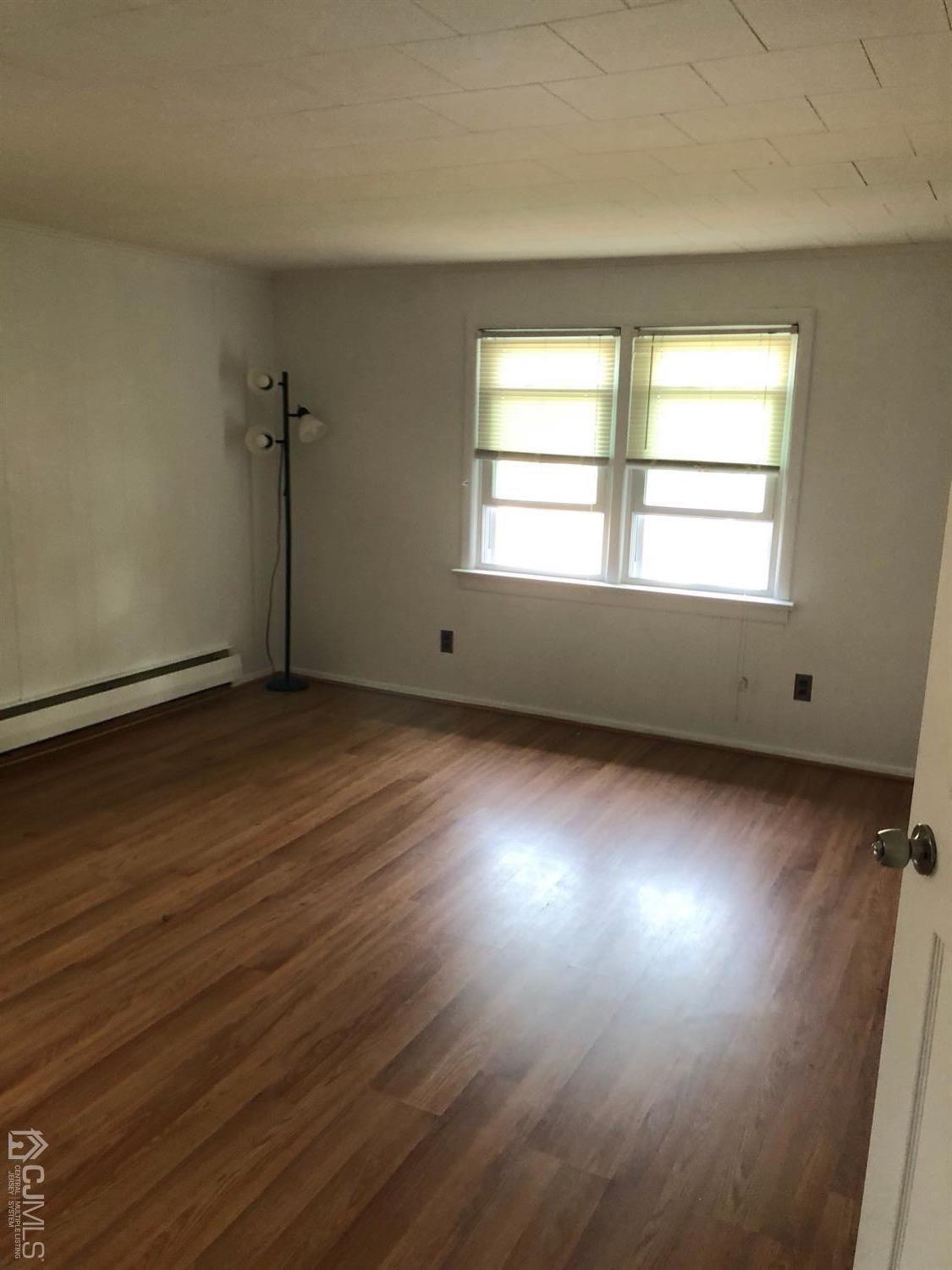 44 Hillcrest Road Colonia, NJ 07067 - Photo 8 of 23 an empty room with wooden floor and windows