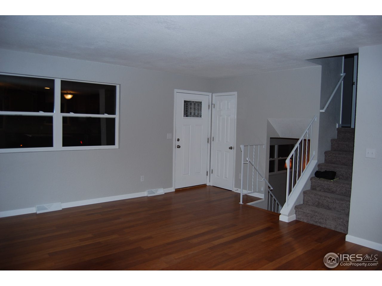 10747 Routt Street Westminster, CO 80021 - Photo 5 of 10 a view of an empty room with wooden floor and stairs