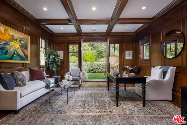 a dining room with wooden floor a chandelier a glass table and chairs