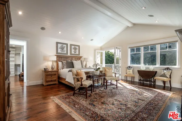 a living room with furniture a rug and a wooden floor