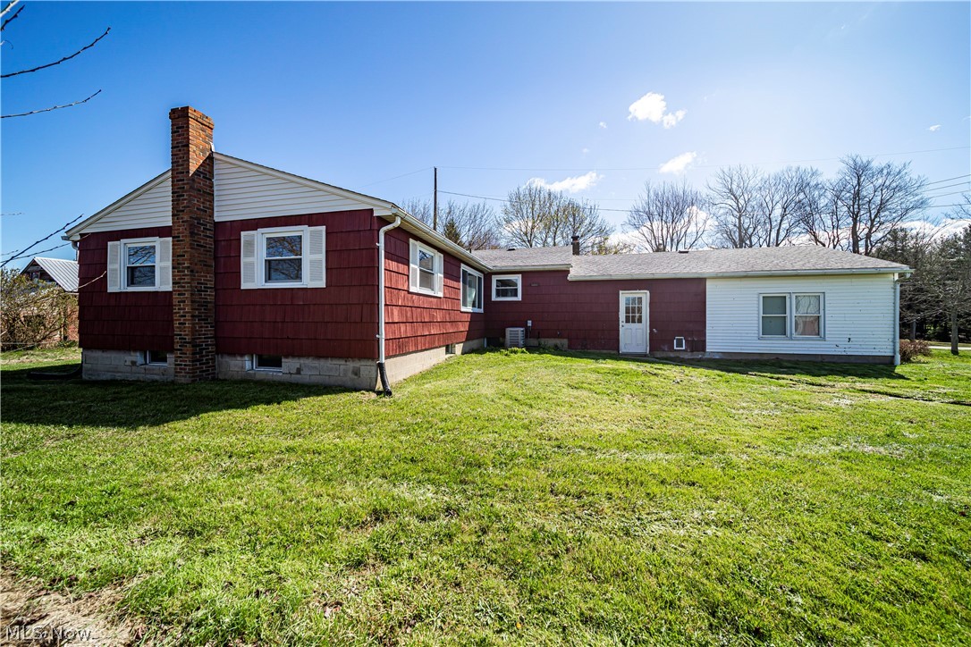 3395 Maple Road Jefferson, OH 44047 - Photo 15 of 36 Back of property featuring central air condition unit and a lawn