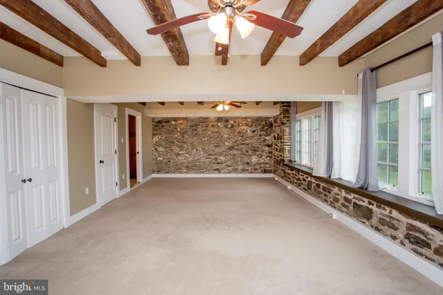 en empty room with windows and ceiling fan