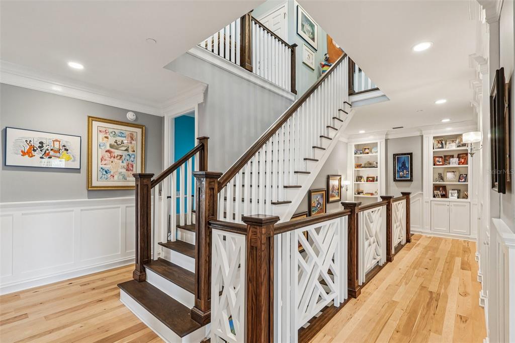 310 Acadia Lane Celebration, FL 34747 - Photo 14 of 52 a view of staircase with lots of frames on wall and wooden floor