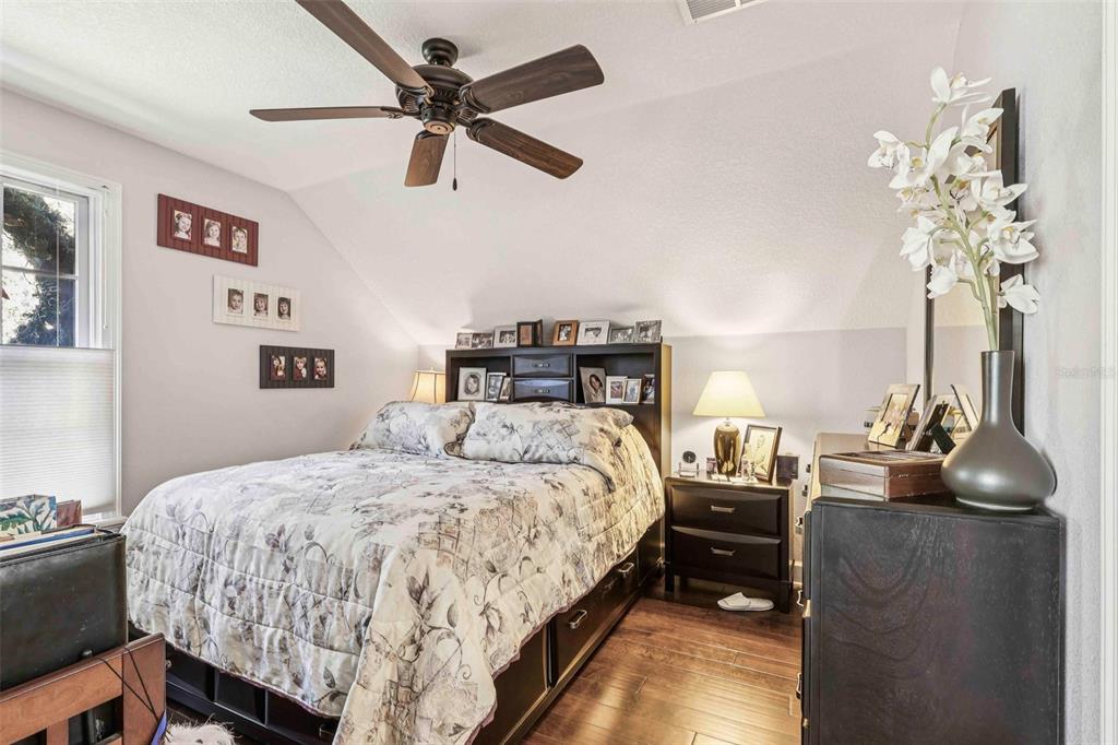 310 Acadia Lane Celebration, FL 34747 - Photo 37 of 52 a bedroom with a bed and a chandelier