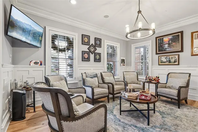 a living room with furniture a chandelier and kitchen view