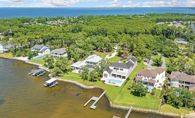 an aerial view of a house with a yard and lake view