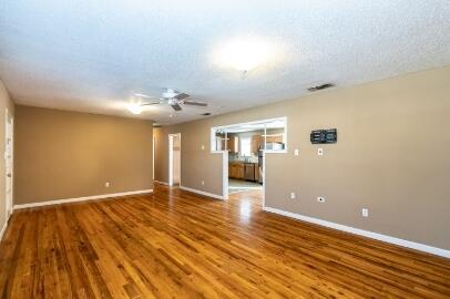 4007 39th Street Lubbock, TX 79413 - Photo 4 of 16 a view of an empty room with wooden floor and a kitchen