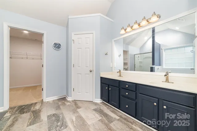 a spacious bathroom with a granite countertop sink mirror and a shower