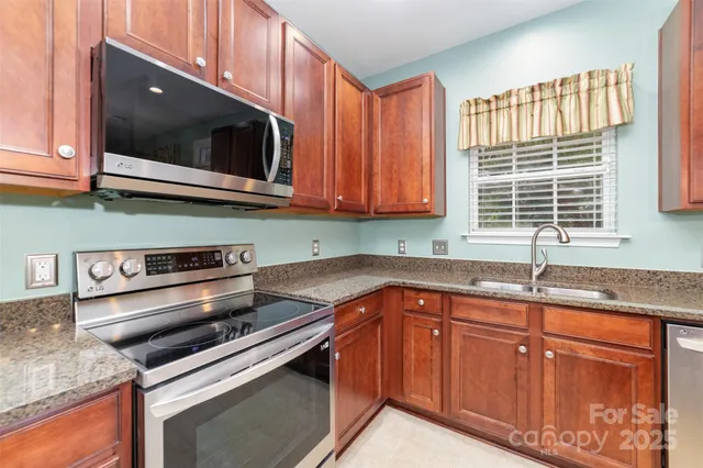 a kitchen with granite countertop a sink and a stove
