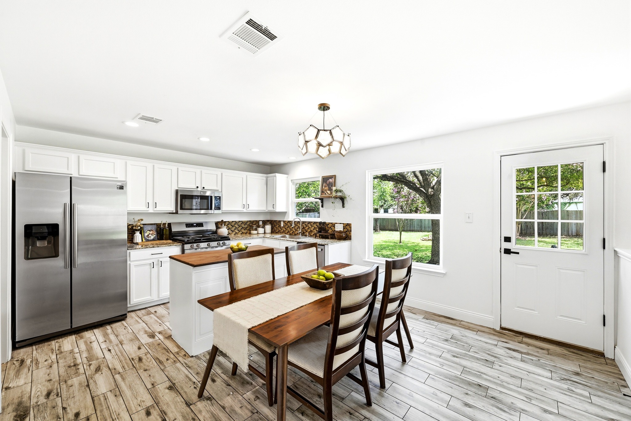 1801 Monks Tale Court Austin, TX 78748 - Photo 7 of 36 Culinary excellence awaits in this bright kitchen, showcasing pristine white cabinetry and direct backyard access.
