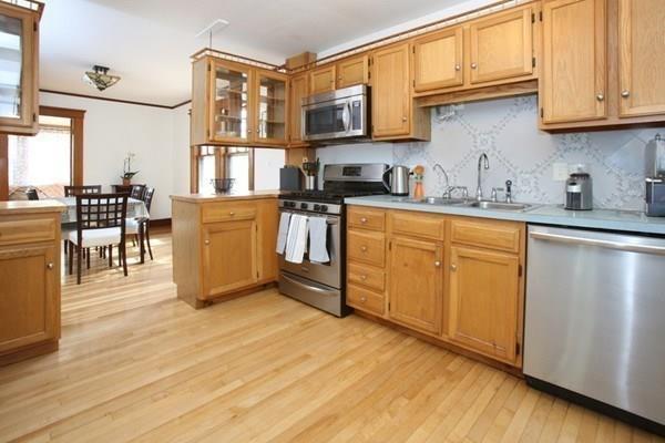 43 Oak Street Newton, MA 02464 - Photo 6 of 20 a kitchen with stainless steel appliances granite countertop a stove top oven a sink dishwasher and white cabinets with wooden floor