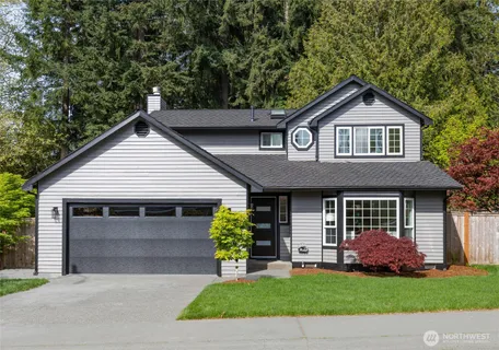 a front view of a house with a garden and garage