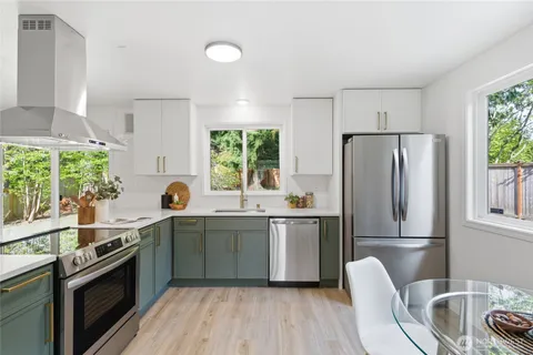 a kitchen with stainless steel appliances a sink stove and cabinets
