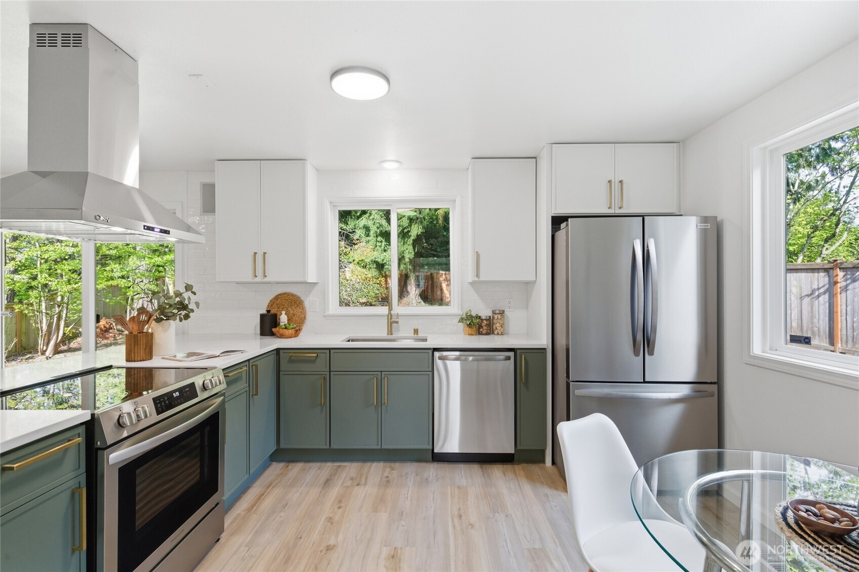 19419 133rd Avenue Southeast Renton, WA 98058 - Photo 12 of 40 a kitchen with stainless steel appliances granite countertop a refrigerator a sink dishwasher a stove and white countertops with wooden floor