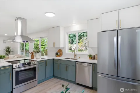 a kitchen with stainless steel appliances a table chairs and a refrigerator