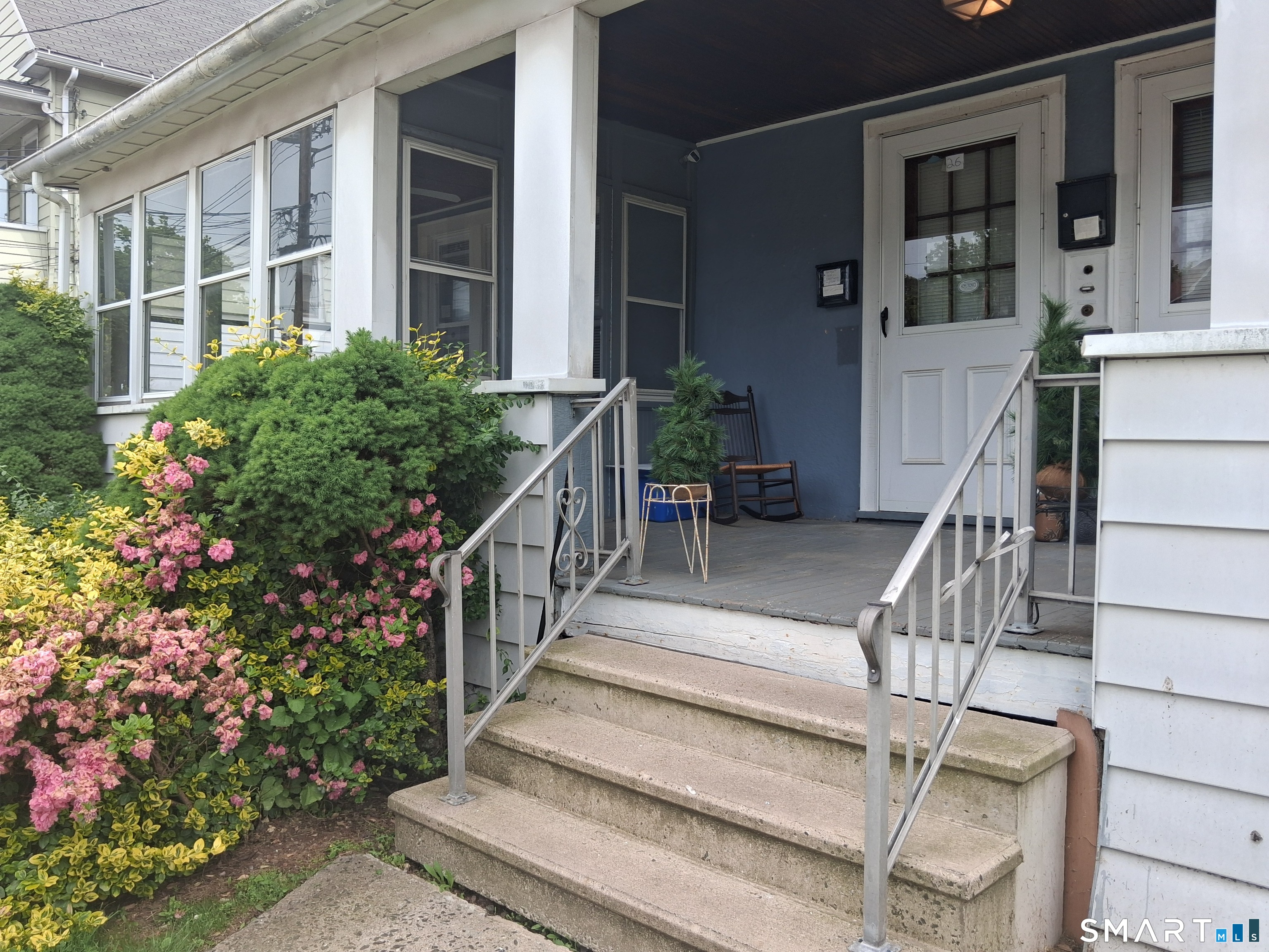 a view of house with wooden stairs and a flower pot