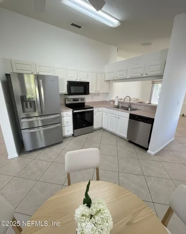 a kitchen with stainless steel appliances granite countertop a refrigerator and a stove top oven