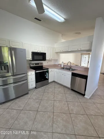a kitchen with stainless steel appliances granite countertop a refrigerator and a stove top oven