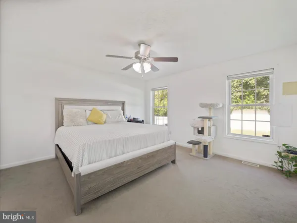a bed sitting in a spacious bedroom next to a window