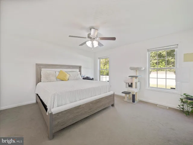 a bed sitting in a spacious bedroom next to a window