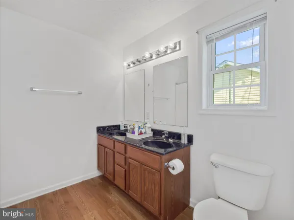 a bathroom with a granite countertop toilet sink and mirror