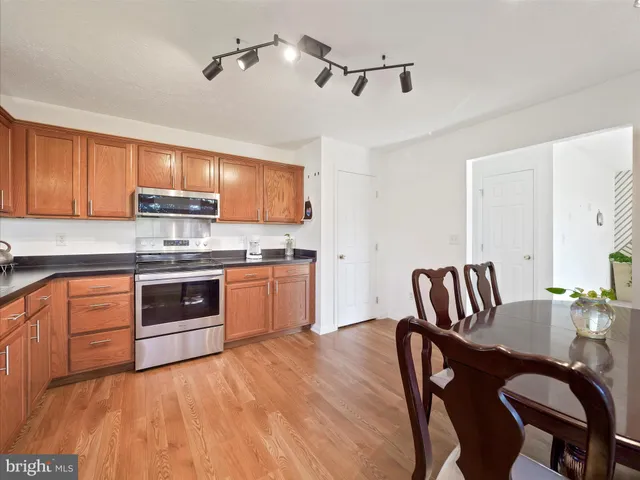 a kitchen with stainless steel appliances granite countertop a stove a sink dishwasher a microwave oven with a dining table and chairs