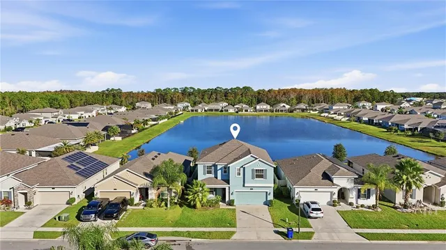 an aerial view of residential houses with outdoor space and ocean view