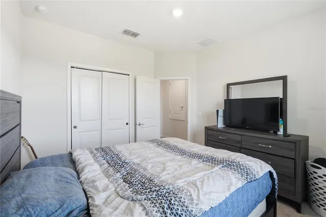 a bedroom with a flat screen tv and a bed