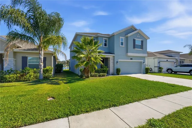a front view of a house with a garden and yard