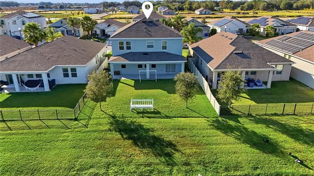 an aerial view of residential houses with yard and green space