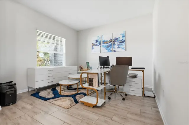 a view of a workspace with furniture and a window