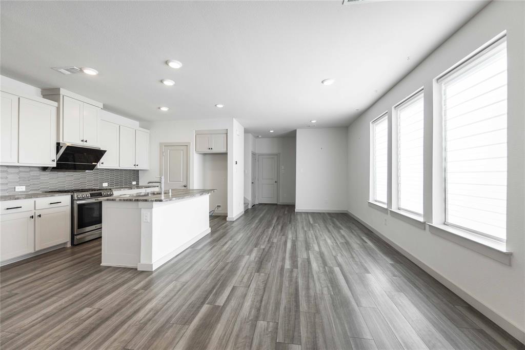 208 Spring Hill Road Flower Mound, TX 75028 - Photo 11 of 35 a kitchen with a sink wooden floor stainless steel appliances and cabinets