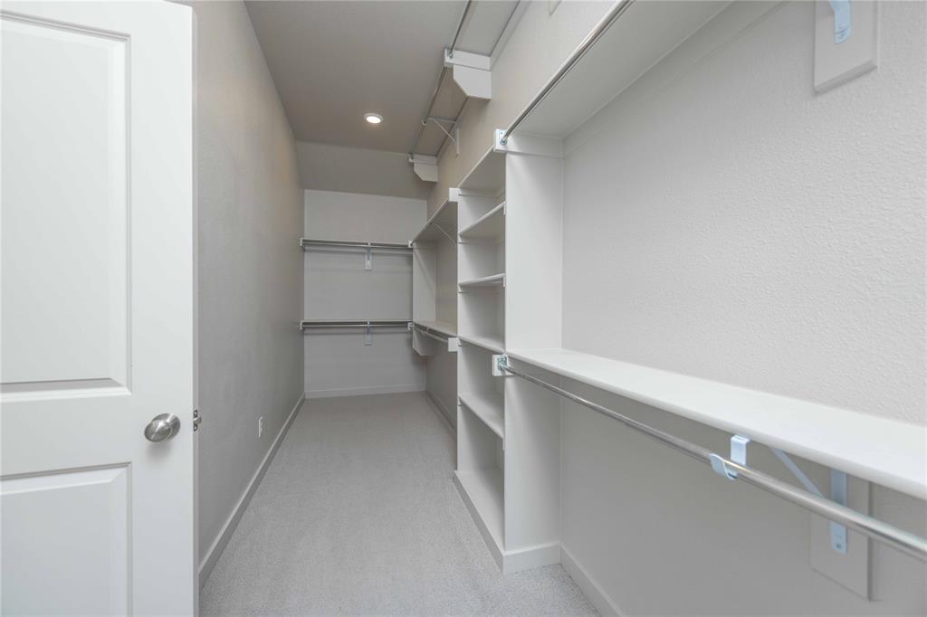 208 Spring Hill Road Flower Mound, TX 75028 - Photo 19 of 35 a view of walk in closet with empty racks