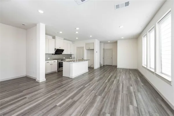 a view of kitchen view wooden floors appliances and cabinets