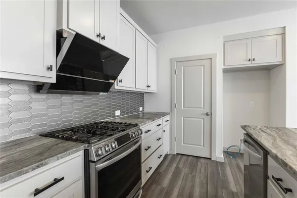 a kitchen with granite countertop a stove and a microwave