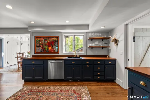 a living room with stainless steel appliances granite countertop a refrigerator and a dresser
