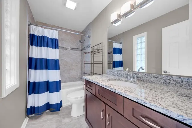 a bathroom with a sink a toilet a shower and a mirror