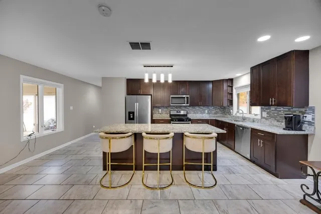a kitchen with a sink and chairs