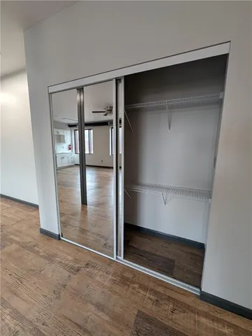 an empty room with wooden floor and entrance