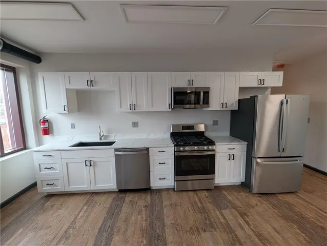 a kitchen with stainless steel appliances a refrigerator sink and stove