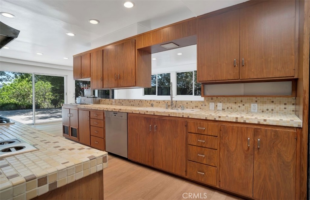 16459 Garvin Drive Encino, CA 91436 - Photo 11 of 26 a kitchen with a sink stove and cabinets