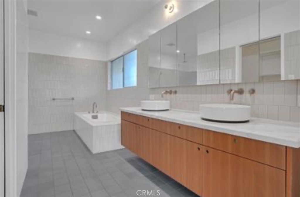 16459 Garvin Drive Encino, CA 91436 - Photo 18 of 26 a bathroom with a granite countertop sink mirror and bathtub