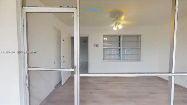 an entryway view with wooden floor and cabinet