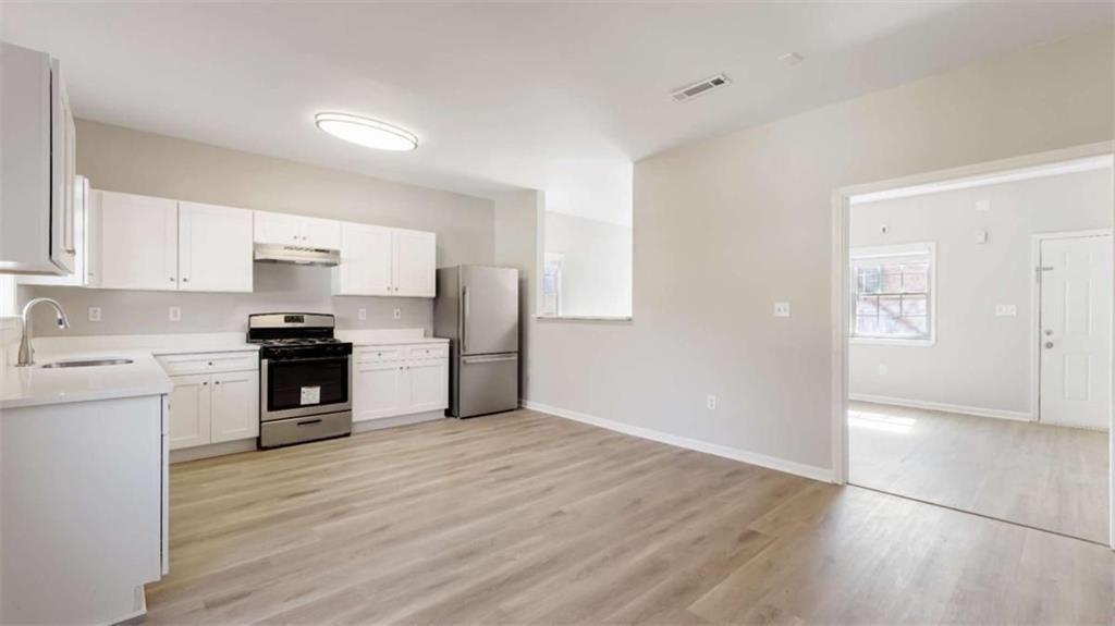 848 Ridge Avenue Northwest, Unit A Atlanta, GA 30318 - Photo 6 of 26 a kitchen with granite countertop a refrigerator and a stove top oven