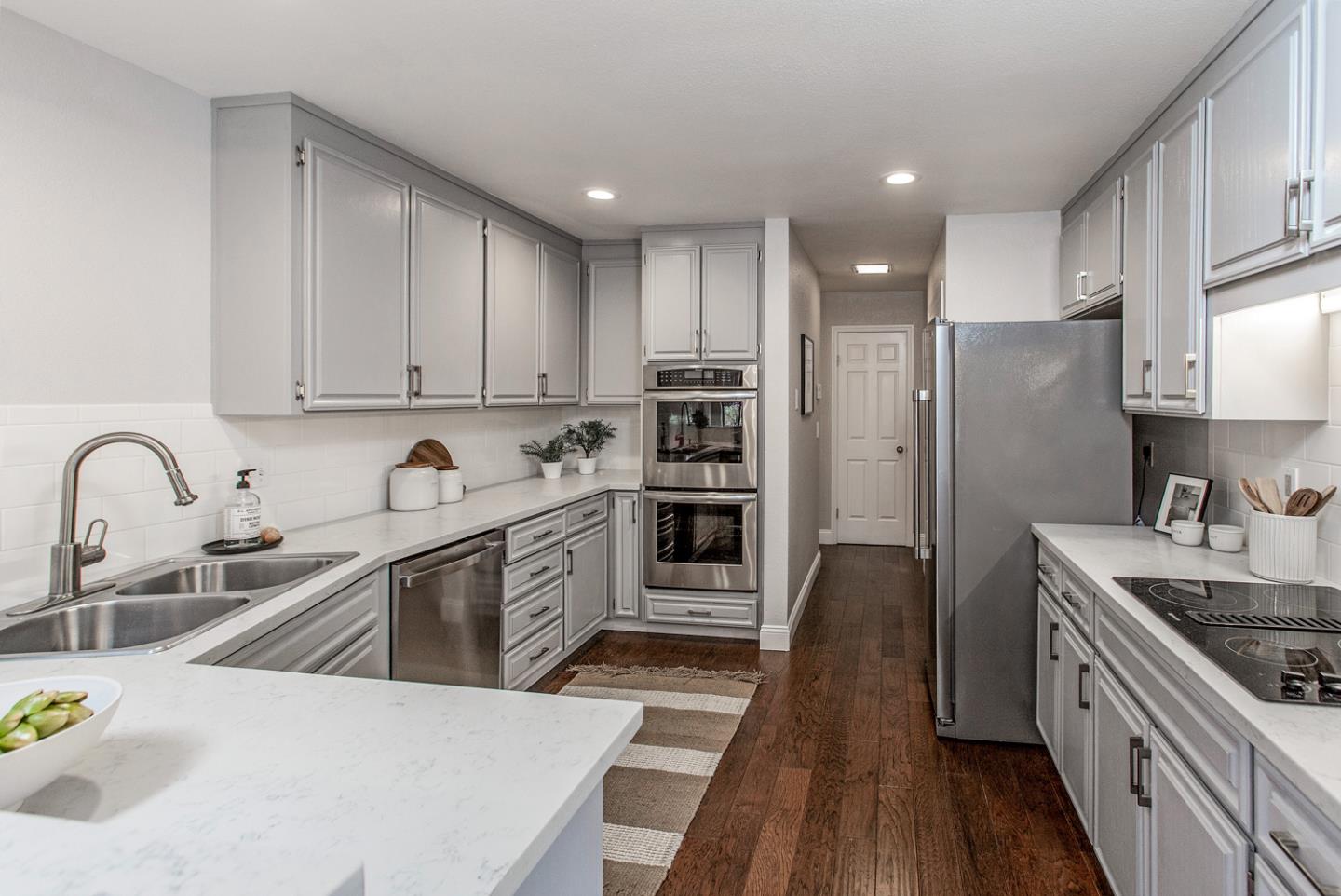 2080 Marich Way, Unit 8 Mountain View, CA 94040 - Photo 8 of 23 a kitchen with stainless steel appliances a sink a stove a refrigerator cabinets and a wooden floor