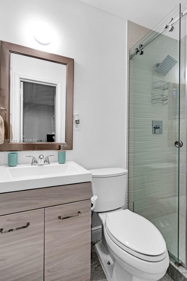 1165 Southwest 4th Terrace Pompano Beach, FL 33060 - Photo 28 of 42 a bathroom with a toilet sink vanity and mirror