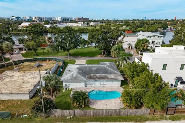 an aerial view of a house with a garden and lake view